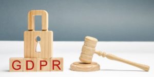 Scritta GDPR con lucchetto, simbolo della privacy e martelletto da giudice che dà una sanzione