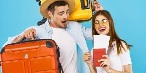 Immagine con un uomo ed una donna pronti a partire, con valigie e passaporto in mano