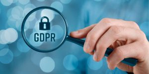 Mano con lente di ingrandimento sulla scritta GDPR