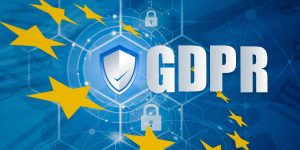 Scritta GDPR con a fianco un sigillo e forma di scudo tutto circondato da stelle come bandiera UE