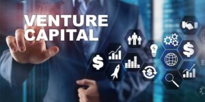 Scritta virtuale "Venture Capital" con altre immagini virtuali e dita di uomo che clicca sulla scritta.