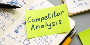 Quaderni con scritte relative ad analisi dei competitor e post-it con scritta "competitor analysis"